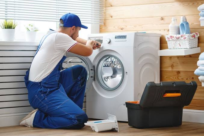 Technician working on a laundry appliance at home