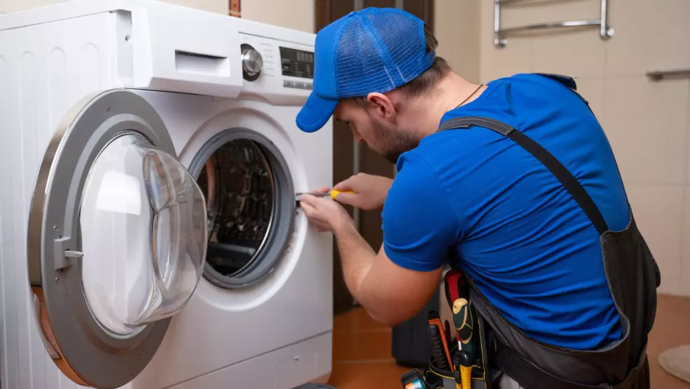 Technician repairing a front-load washing machine